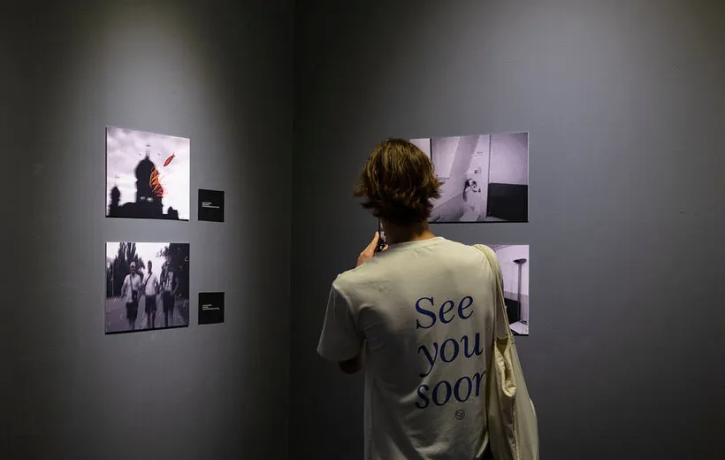 A visitor looking at framed works