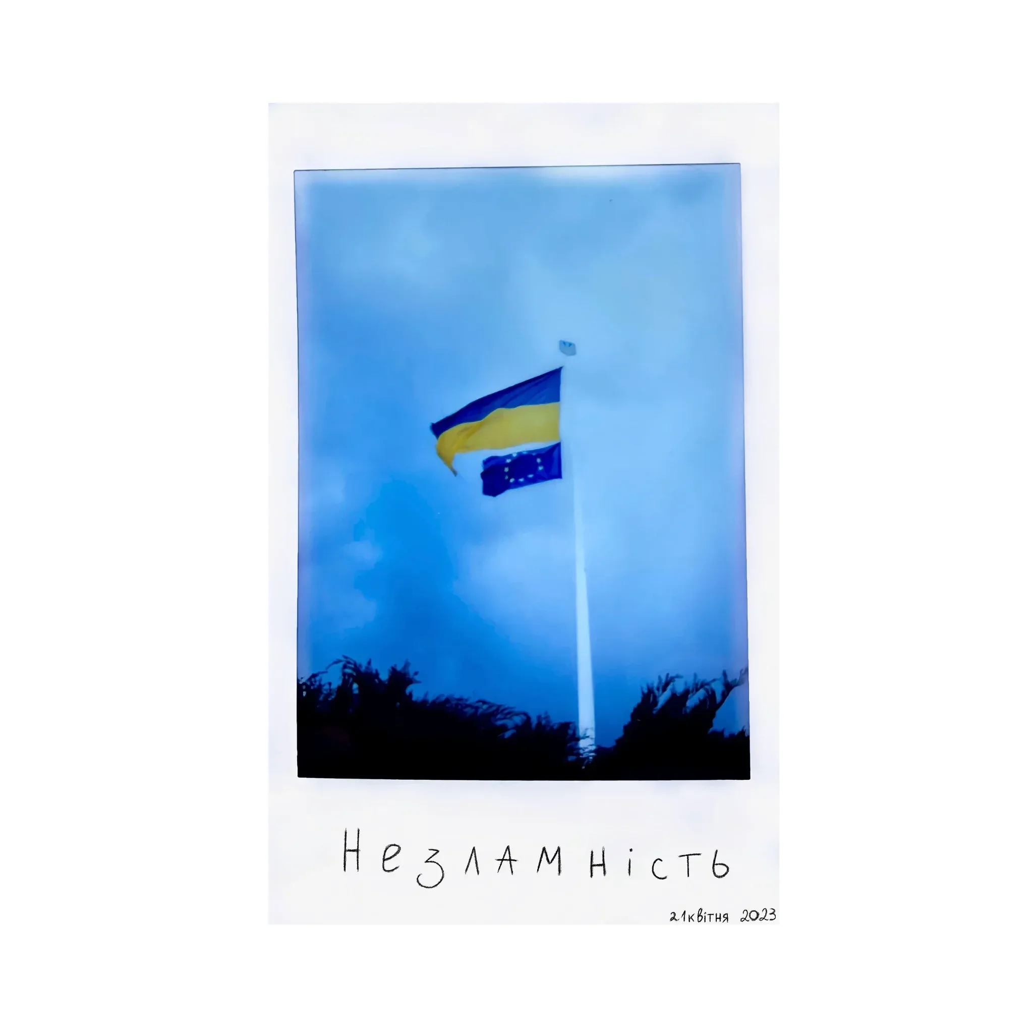 Polaroid of the Ukrainian flag against a blue sky